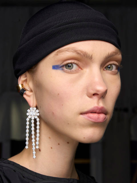 Blaue Augen zeigt ein Model mit blauem Lidschatten als Balken des äußeren Augenwinkels.