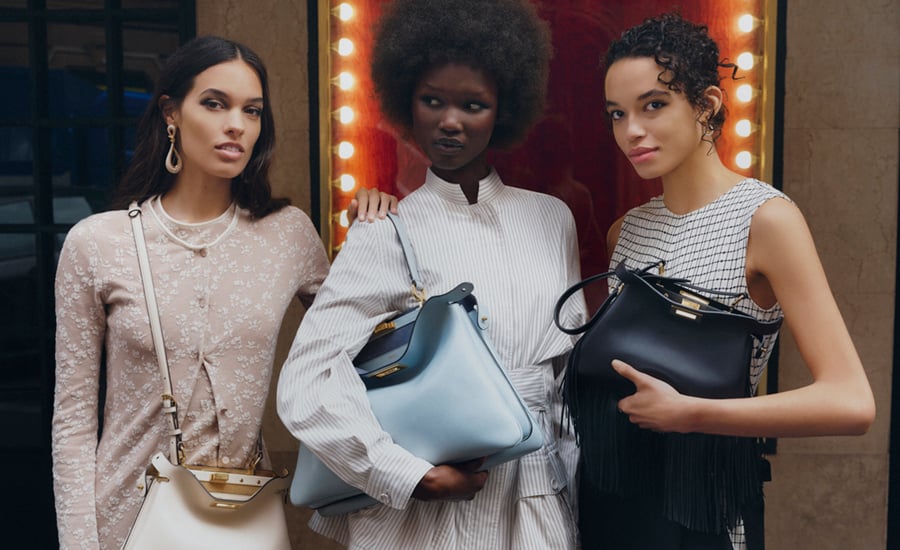 Drei Modells tragen die neuen Designer-Taschen für Frühjahr/Sommer 2025 von Fendi. Darunter eine „Peekaboo Soft Small“ in Off-White, eine klassische "Peekabo Soft Large" in Hellblau sowie eine schwarze „Peekaboo Soft Small“ mit Fransen-Dekor.