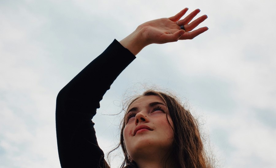 Frau hebt Hand in die Höhe