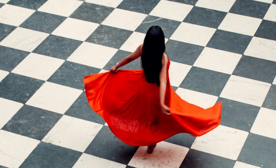 Frau in rotem Kleid auf karierten Fliesen