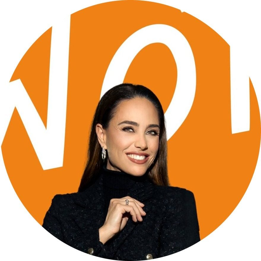 Franca Lehfeldt lächelnd im schwarzen Blazer vor einem orangefarbenen WOT-Schriftzug
