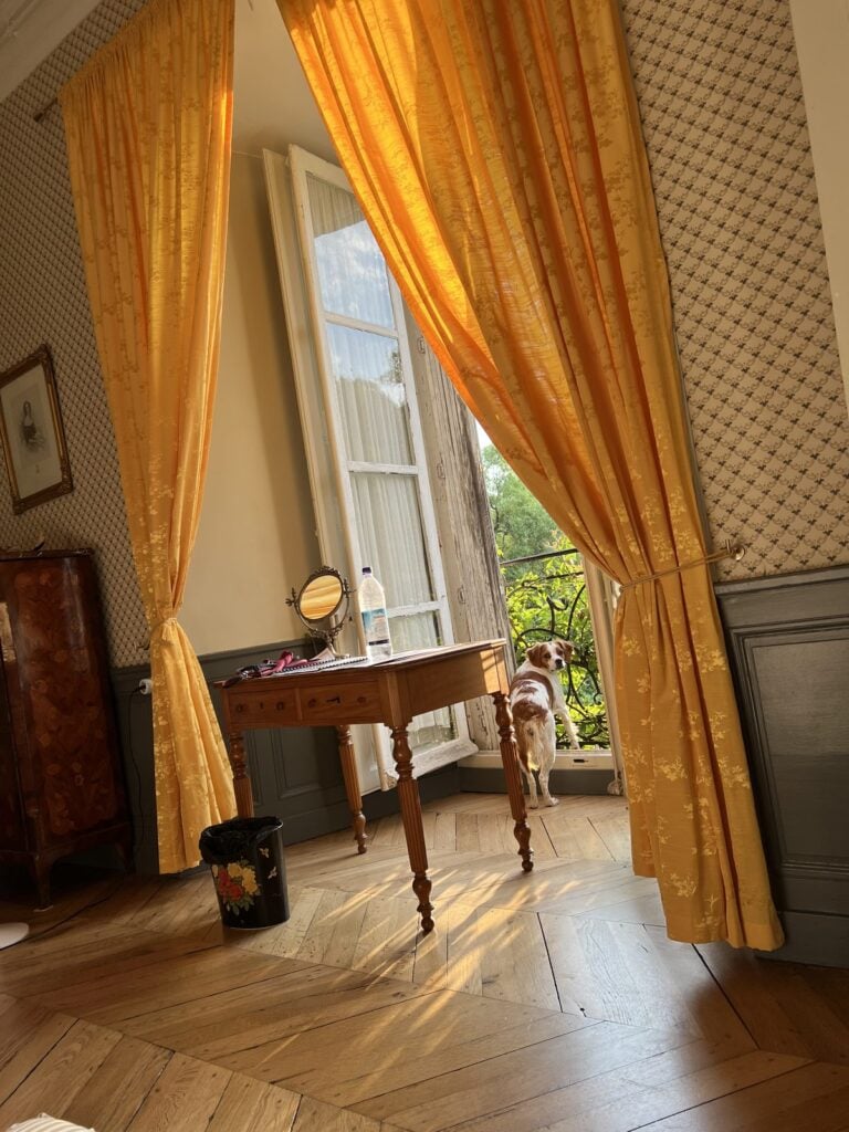 Zimmer im Château mit gelben Vorhängen und Schreibtisch am Fenster