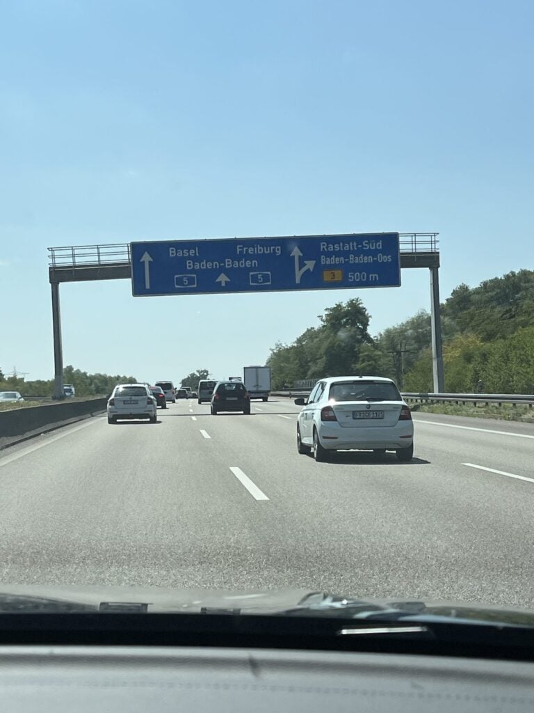 Autobahn mit Schilderbrücke, aus dem Auto fotografiert