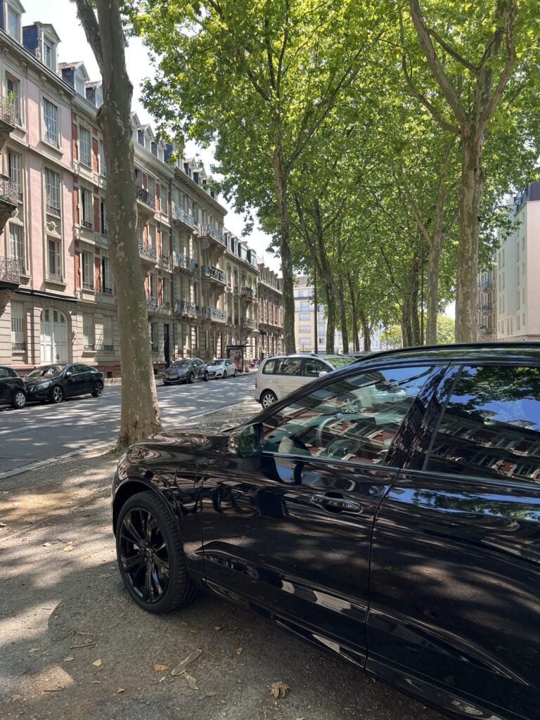 Schwarzer Volvo XC60 geparkt unter Bäumen in einer Straße in Straßburg