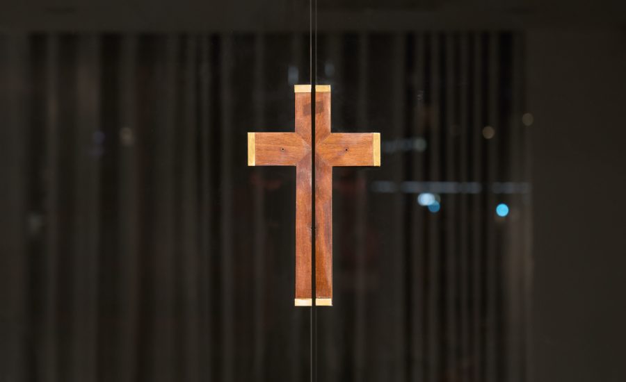 Jiyoon Chung, Untitled, 2026, Rail: 320 x 15 x 10 cm,  glass door: 296 x 260 x 0.8 cm, Rosewood crucifix with corpus missing, (c. 1970s), automatic sliding door system, glass, aluminum, Courtesy of the Artist and Anton Janizewski,  Copyright Brian Kure